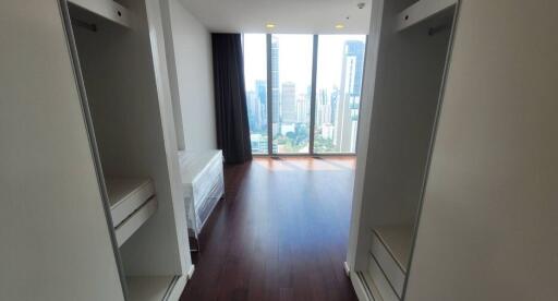 Spacious bedroom with city view and wooden flooring