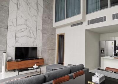 Modern living area with high ceiling and marble accent wall