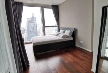 Modern bedroom with large windows and an urban view