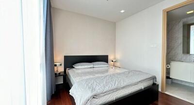 Modern bedroom with double bed, bedside tables, and ensuite bathroom