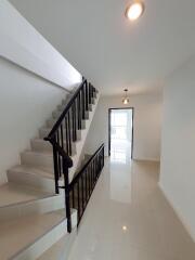 Bright hallway with staircase and modern lighting