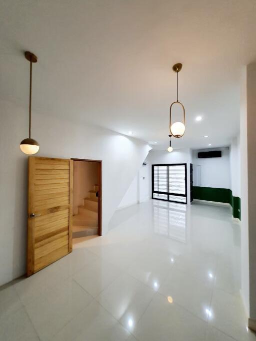 Spacious modern living room with pendant lights and staircase