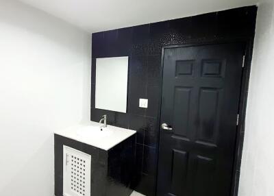 Modern bathroom with black door and vanity