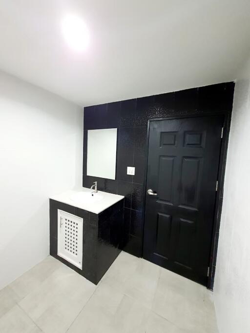 Modern bathroom with black door and vanity