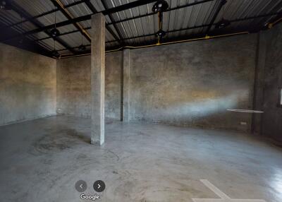 Spacious industrial-style room with concrete floors and large support pillar