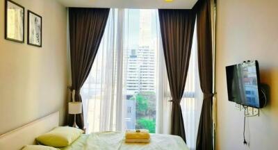 Modern bedroom with floor-to-ceiling windows and city view