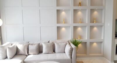 Modern living room with built-in shelving and decorative pillows on a gray couch