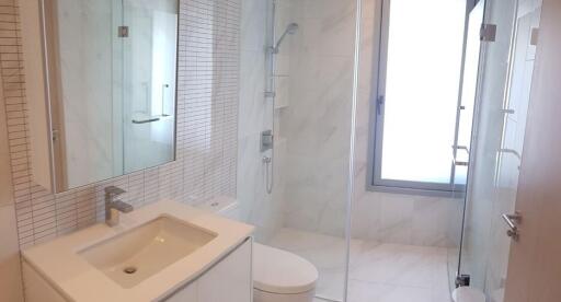 Modern bathroom with glass shower and vanity.