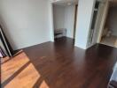 Sunlit bedroom with dark wood flooring