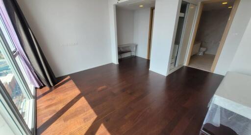 Sunlit bedroom with dark wood flooring