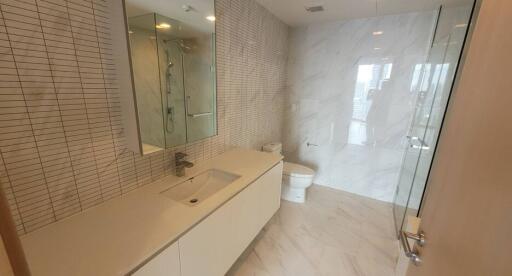 Modern bathroom with a large mirror and glass-enclosed shower