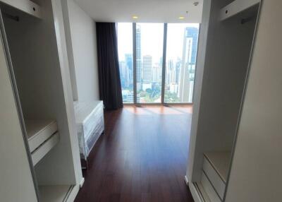 Walk-in closet facing bedroom with large windows and city view