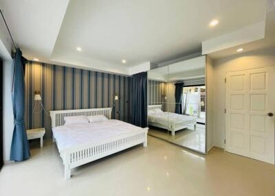 modern bedroom with large mirrored closet and minimalist decor