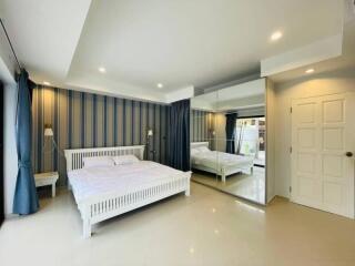 modern bedroom with large mirrored closet and minimalist decor