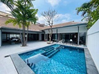 Luxurious pool area with modern patio and surrounding greenery