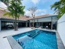 Luxurious pool area with modern patio and surrounding greenery