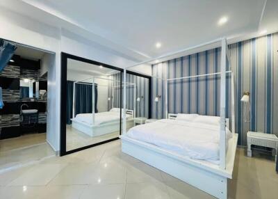 Spacious bedroom with large mirrored wardrobe and modern decor