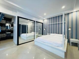 Spacious bedroom with large mirrored wardrobe and modern decor