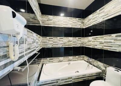Modern bathroom with bathtub and tiled walls