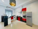 Modern kitchen with red and black cabinets, stainless steel appliances, and white countertops