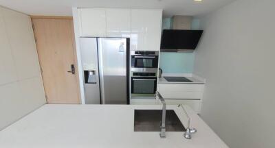 Modern white kitchen with stainless steel appliances and island sink