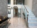 Modern building lobby with marble floors and glass railing stairs