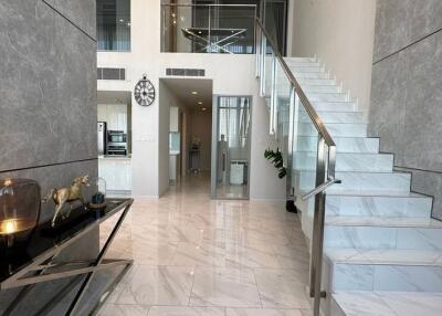 Modern hallway with glass staircase and decorative elements