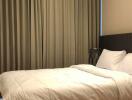 Well-lit bedroom with a double bed and neutral-toned curtains