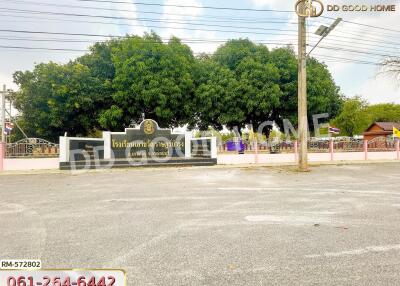 Entrance of a real estate property with parking space and green trees