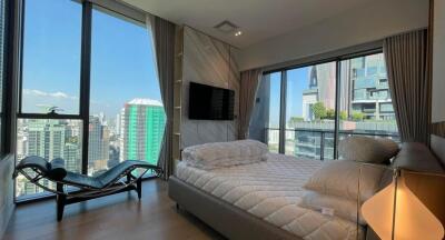 Modern bedroom with city view from large windows