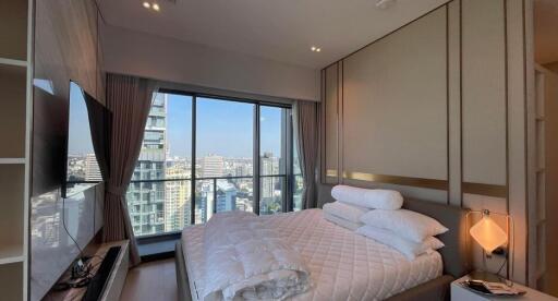 Modern bedroom with a large window offering a city view