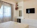 Bedroom with a window, curtains, bed, vanity table, and wall-mounted TV