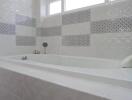 Modern bathroom with bathtub and decorative tiles