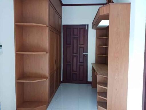 Bedroom with built-in wooden shelves and cabinets