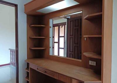 Bedroom with a built-in wooden vanity unit and shelves