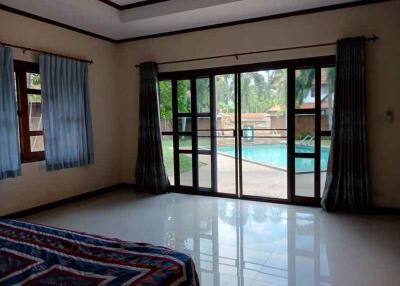 Bedroom with large windows and pool view
