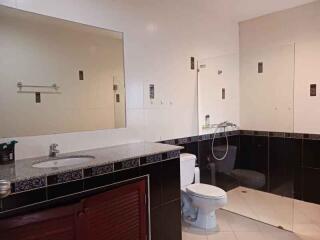 Modern bathroom with spacious mirror and tiled walls