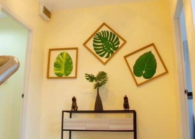 Decorated hallway with framed leaf art and console table