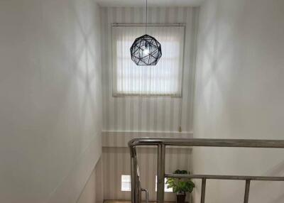 Stairwell with a modern light fixture and a window with blinds