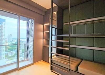 Bedroom with green bunk beds and a large window overlooking a cityscape