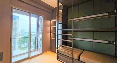 Bedroom with green bunk beds and a large window overlooking a cityscape