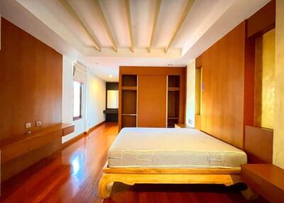 Spacious bedroom with wooden flooring and modern furniture