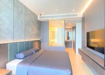 Modern bedroom with a large bed, mounted TV, and en suite bathroom