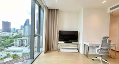 Modern living area with a city view, featuring a wall-mounted TV and a home office setup