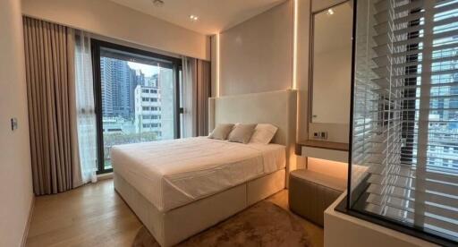 Modern bedroom with a large window and city view.