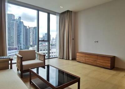 Spacious living room with modern furniture and large windows overlooking the city