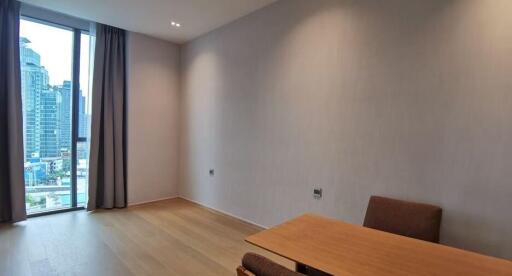 Partially furnished living room with city view windows