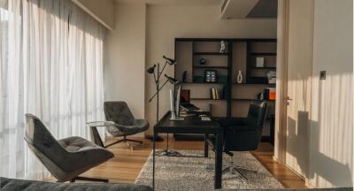 Modern home office with large windows and bookshelf