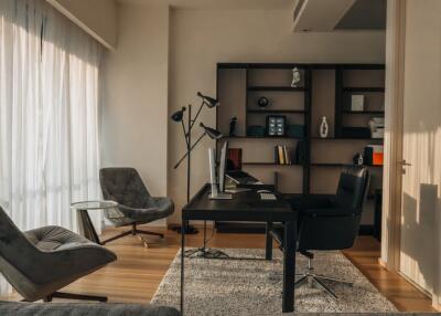 Modern home office with desk, bookshelves, and seating area