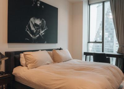 Modern bedroom with large bed and artwork above the headboard